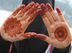 a woman's hands with henna tattoos on them