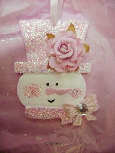 a pink rose sitting on top of a white box with sequins around it