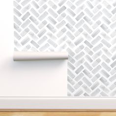 a white wall with a pattern on it and a roll of paper next to it