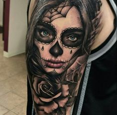 a woman's arm with a skull and rose tattoo on it