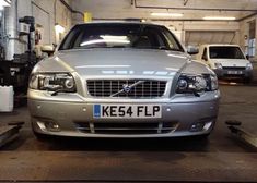 a silver car parked in a garage next to other cars