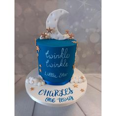 a blue cake decorated with stars and a crescent on the top that says twinkle twinkle little star