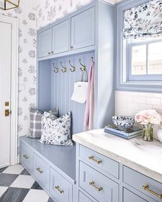 a bathroom with blue cabinets and white counter tops in front of a checkered floor