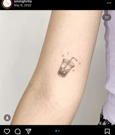 a woman's arm with a small tattoo of a drink on the left side of her arm