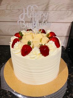 a white cake topped with strawberries and frosting