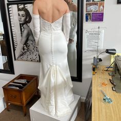 the back of a woman's wedding dress in front of a mirror