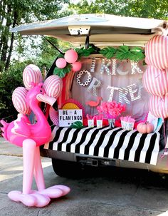 a pink flamingo themed birthday party with balloons and decorations in the back of a car