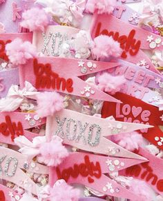 pink and red valentine's day ribbons with love words on them are scattered together