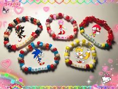 four bracelets with cartoon characters on them and hearts in the background, all decorated with beads