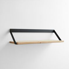 an empty shelf on the wall with some black metal and wood shelves above it,