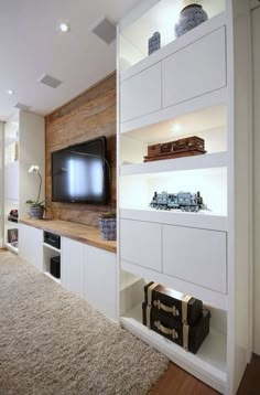 a living room filled with furniture and a flat screen tv on top of a wooden shelf