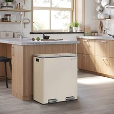 a white refrigerator sitting inside of a kitchen next to a window