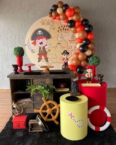 an assortment of pirate decorations and balloons on display in a room with a black rug