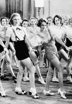 a group of women in short skirts are dancing