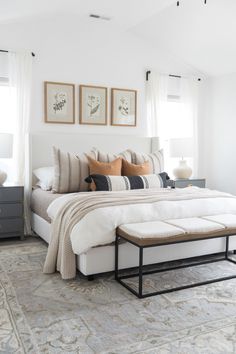 a large bed sitting next to two windows in a bedroom on top of a rug