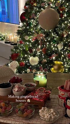 a christmas tree is decorated with candy and other holiday treats in front of the tv