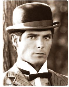 a man in a suit and top hat is staring at the camera with an intense look on his face