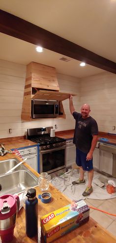 a man is standing in the middle of a kitchen remodeling project with supplies on the floor