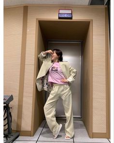 a woman standing in an elevator with her hands on her hips and looking up at the ceiling