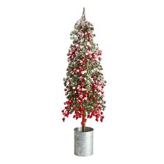 a small christmas tree with red berries and green leaves in a metal pot on a white background