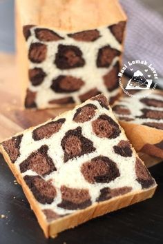 two slices of brown and white cake sitting on top of a wooden cutting board