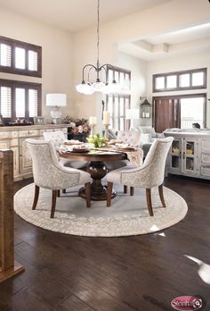 a dining room table with chairs around it in the middle of a living room area