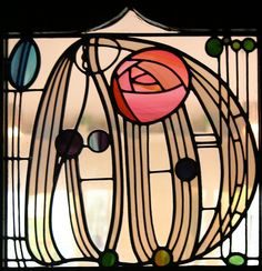 a close up of a stained glass window with a rose on it's side