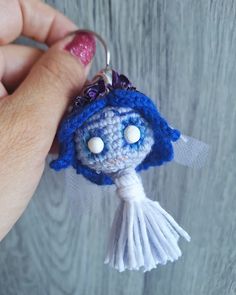 a crocheted keychain with a blue and white owl on it's face