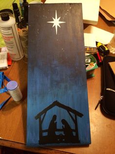 a nativity scene painted on a wooden board