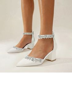 a woman wearing white high heels with crystal embellishments