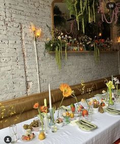 a long table is set with flowers and candles for an elegant dinner or brunch