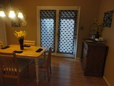 a dining room table with four chairs next to a door