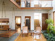 a living room filled with lots of furniture next to a stair case and wooden floors