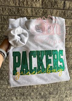 a person holding onto a t - shirt with the word packers on it