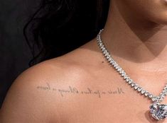 a close up of a woman's chest with a heart shaped diamond necklace on it