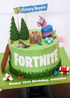 a birthday cake for a fortnite themed party with toys and decorations on it