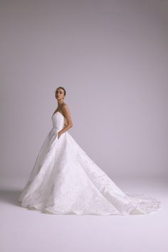 a woman in a white wedding dress posing for the camera with her hands on her hips