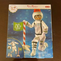 a paper doll with an astronaut outfit and candy cane