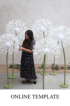 a woman standing in front of some white flowers