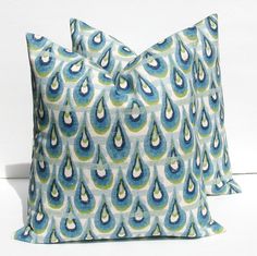 two blue and green pillows with water drops on the front, one is made out of linen