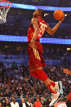 a basketball player is jumping up to dunk the ball in front of an audience