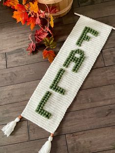 a cross stitch banner with the word fall spelled in green