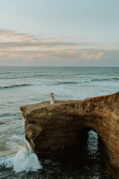 a person standing on top of a cliff near the ocean