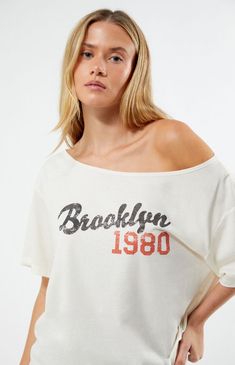 Show off your laid-back style with the Brooklyn 1980 Off-The-Shoulder T-Shirt from PS / LA. This tee features an off-the-shoulder design, short sleeves, a Brooklyn 1980 front graphic, and an oversized relaxed fit for a comfortable, effortlessly cool look.Solid color teeShort sleevesOff-the-shoulder designFront graphicOversized fit50% cotton, 50% polyesterMachine washableModel is wearing a size smallModel measurements: 5’8” height, 31” bust, 23” waist, 36” hips PS / LA Womens Brooklyn 1980 Off-The-Shoulder T-Shirt - White size Medium Vintage Text Print Tops For Summer, Vintage Slogan Tops For Spring, Off The Shoulder T Shirt, Off The Shoulder Tee, Trendy Shirts, Lifestyle Clothing, Shoulder Shirts, Laid Back Style, Pant Shirt