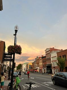 people are riding bikes down the street in front of some shops and buildings at sunset