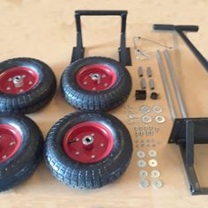 four red wheels are sitting next to each other on a table with screws and nuts