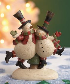 two snowmen hugging each other on top of a table