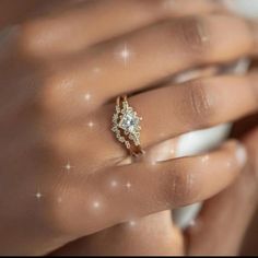 a woman's hand with a diamond ring on top of her finger and the other hand holding it