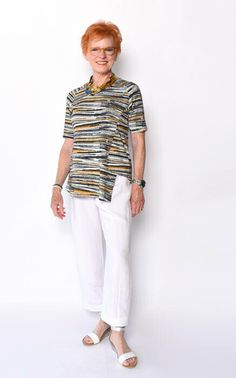 an older woman standing in front of a white wall with her hands on her hips