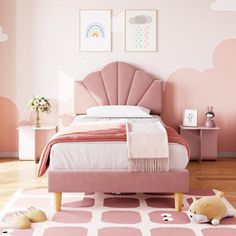 a child's bedroom with pink and white decor, including an upholstered bed